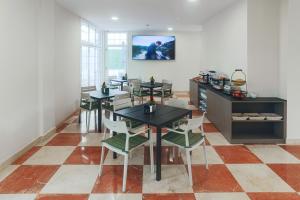 a dining room with tables and chairs and a tv at STAR BAY Hotel in Calafell