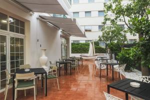 a patio with tables and chairs and a building at STAR BAY Hotel in Calafell