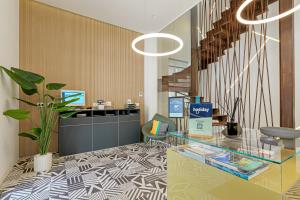 a lobby with a glass table and a staircase at HOTIDAY Olbia Wallure in Olbia