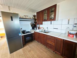 Una cocina con refrigerador de acero inoxidable y gabinetes de madera. en Robinson house Vito, en Bol 14 fotos más