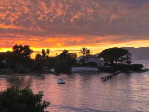 a boat in a body of water with a sunset at Maisonnette 2 minutes pied plage in Grosseto-Prugna +6 photos