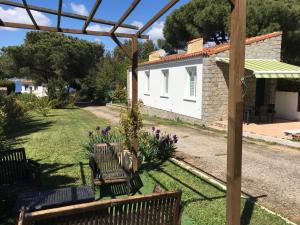 a group of benches in a yard with a house at Maisonnette 2 minutes pied plage in Grosseto-Prugna