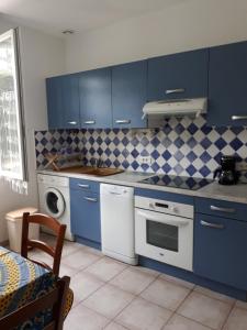 a kitchen with blue cabinets and a washer and dryer at Maisonnette 2 minutes pied plage in Grosseto-Prugna