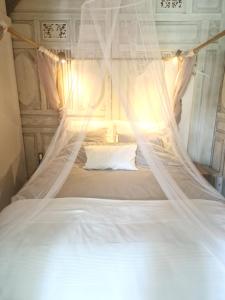 a white bed with a net canopy in a room at The Beach House in Schellinkhout