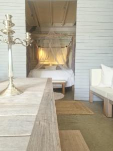 a bedroom with a bed and a bench and a lamp at The Beach House in Schellinkhout