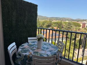 Una mesa con un jarrón de flores en un balcón. en Magnifique Studio Piscine, en Sainte-Maxime
