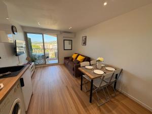 una sala de estar con un sofá y una mesa en Magnifique Studio Piscine, en Sainte-Maxime