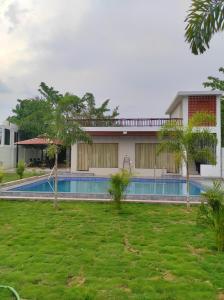 una casa con piscina in giardino di KIMBA FARMS & RESORTS Mangatta a Mūrhīpār