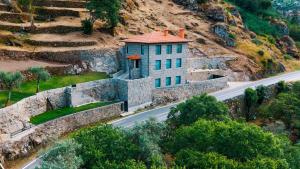 una casa sul fianco di una montagna con una strada di Douro Sky Valley - Private Villa a Miomães