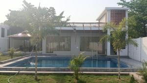 una casa con una piscina di fronte di KIMBA FARMS & RESORTS Mangatta a Mūrhīpār