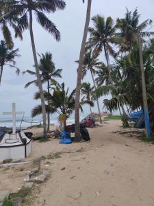 a beach with palm trees and a cross on it at Marari beach homestay in Vayalār