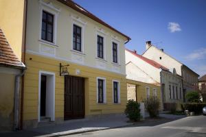 un edificio blanco y amarillo en una calle en Pékapartman, en Kőszeg