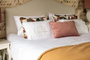 un grande letto con lenzuola bianche e cuscini sopra di Douro Sky Valley - Private Villa a Miomães