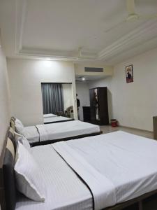 Ένα ή περισσότερα κρεβάτια σε δωμάτιο στο Shri Harichand Hotel