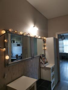 a mirror with lights and a table in a room at Guest House ALEJA in Myza Bene +28 photos