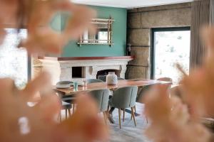 una sala da pranzo con tavolo, sedie e camino di Douro Sky Valley - Private Villa a Miomães