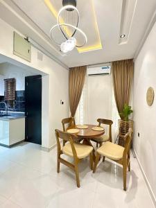 een eetkamer met een tafel en stoelen en een keuken bij Oaksvale Homes in Enugu