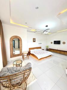 een slaapkamer met een bed, een spiegel en een bank bij Oaksvale Homes in Enugu