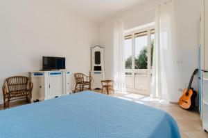 a bedroom with a bed and a tv and a guitar at Casa Vacanza Plautilla - Salento Selection in Maglie