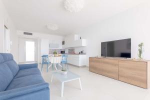 a living room with a blue couch and a tv at Radiluxe - Suite Meliso in Leuca