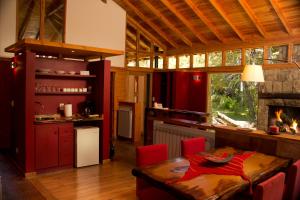 a kitchen and dining room with a table and a fireplace at El Aura Lodge - Parque Nacional Los Alerces in Esquel