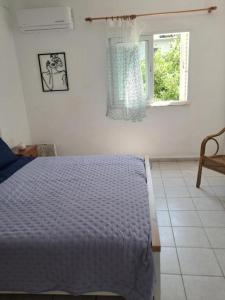 une chambre blanche avec un lit et une fenêtre dans l'établissement House with view the Ionian sea, à Prévéza