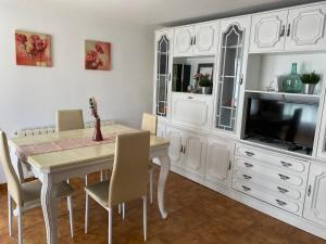 a dining room with a table and a tv at Casa Los Cuncos in Barrio de Lomba