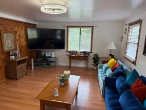 a living room with a blue couch and a table at Susquehanna Waterfall Haven in Susquehanna