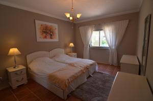 1 dormitorio con cama blanca y ventana en Bonita en Quarteira