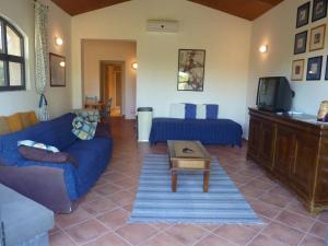 a living room with a blue couch and a tv at Grande, bella villa in Toscana vicino al mare in Capalbio