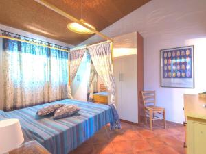 a bedroom with a blue bed and a chair at Grande, bella villa in Toscana vicino al mare in Capalbio