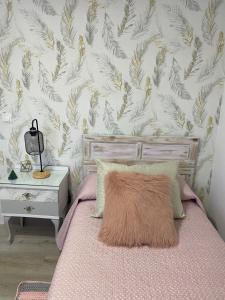 a bedroom with a bed and a wall covered in leaves at Casa Los Cuncos in Barrio de Lomba