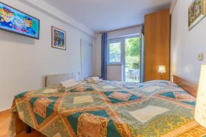 een slaapkamer met een groot bed en een raam bij Garden Rooms Chiara in Poreč