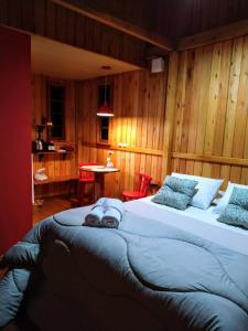 ein großes Bett in einem Zimmer mit Holzwänden in der Unterkunft Cabana Vita Bella in Nova Trento