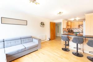 a living room with a couch and a kitchen at Stylish Two-Bedroom Flat in Marylebone in London