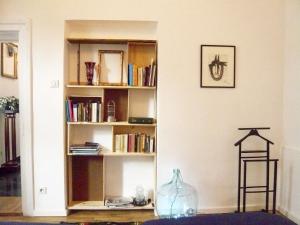 een kamer met een boekenplank met boeken en een vaas bij Augusta in Cluj-Napoca