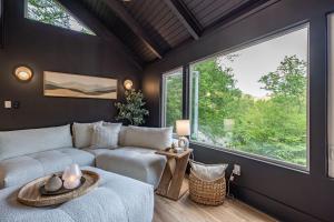 a living room with a couch and a large window at Stunning Views Private Sauna Fireplace Fire Pit in Sugar Mountain +59 photos