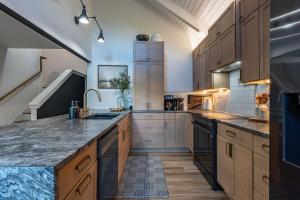 a large kitchen with wooden cabinets and granite counter tops at Stunning Views Private Sauna Fireplace Fire Pit in Sugar Mountain