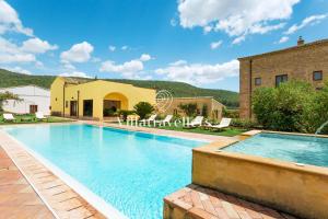 a villa with a swimming pool and a building at Casale degli Erei in San Michele di Ganzaria