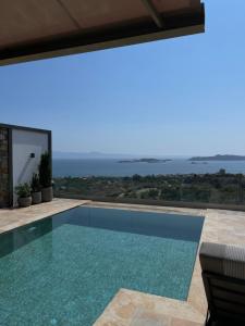 a swimming pool with a view of the ocean at Elia Luxury House in Ouranoupoli