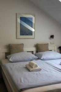 two beds with a towel on top of them at Pension Katzensprung in Passau