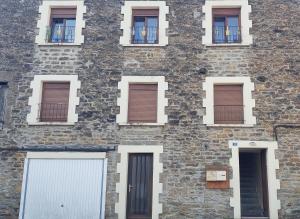 a brick building with white doors and windows at Le Nid Daudèce in Le Châtelet-sur-Sormonne +6 photos