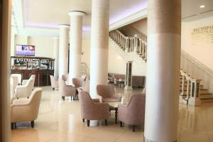 una hall con sedie, tavoli e colonne di Ukraine Hotel a Kiev
