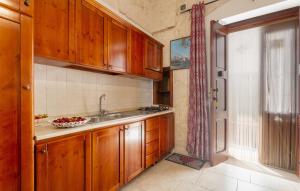 Una cocina con gabinetes de madera y un fregadero. en Apartment The Barco, en Ostuni