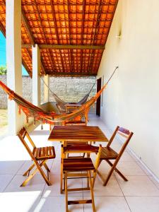 a hammock in a room with chairs and a table at Casa Atalaia Paraíso in Atalaia