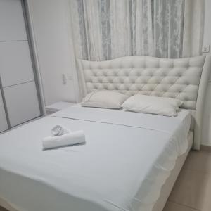 a bedroom with a white bed with a large mirror at Royal park LUXURY apartment in Eilat