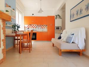 a kitchen with orange cabinets and a couch and a table at Casa Galilei 5 minuti dal mare in San Salvo