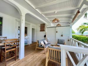 a room with a porch with a table and chairs at La p’tite barque Antillaise in Deshaies