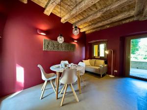 a dining room with red walls and a table and chairs at Casa LoVi in Borgosesia