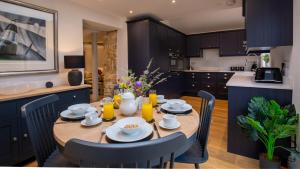 a kitchen with a wooden table and chairs in a kitchen at Primrose Cottage in Chipping Campden